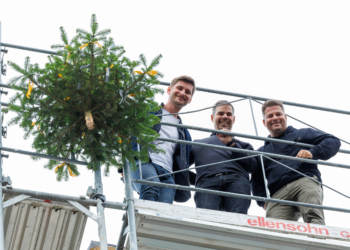 Handwerker ziehen den traditionellen Firstbaum auf das Dach der fertigen Rohbauten am Garnmarkt Ost. (Foto: Bernd Hofmeister)