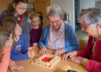 Zwei ältere Damen lassen sich von Kindern das Spiel “Klappbrett” erklären. Ein Bild, das zeigt, wie mühelos Barrieren am Spieltisch verschwinden. Fotos: Johannes Rinderer