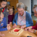 Zwei ältere Damen lassen sich von Kindern das Spiel “Klappbrett” erklären. Ein Bild, das zeigt, wie mühelos Barrieren am Spieltisch verschwinden. Fotos: Johannes Rinderer